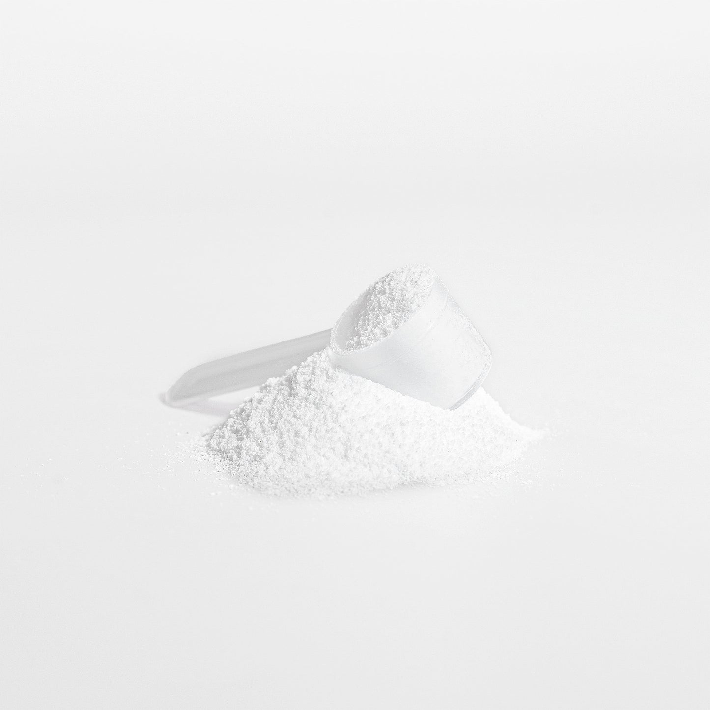 White creatine powder in a measuring spoon on a white background