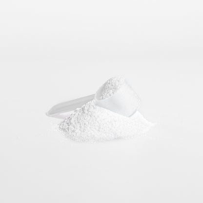 White creatine powder in a measuring spoon on a white background